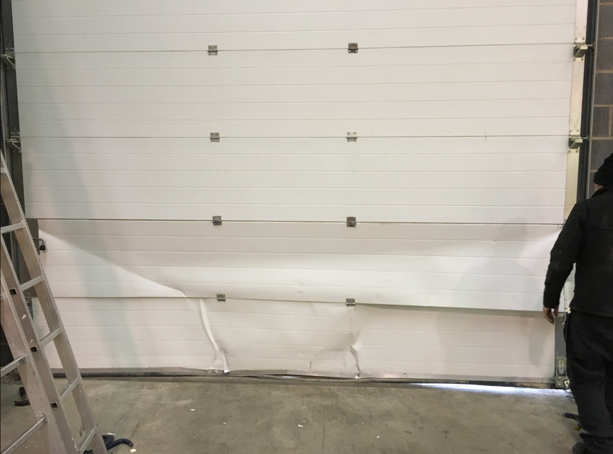 A professional technician performing garage door panel repair on a residential garage door in Dublin, ensuring smooth and secure operation.