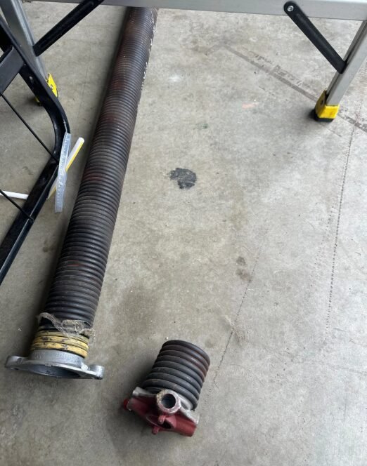 a technician performing garage door spring repair in Delaware, Ohio, demonstrating professional service and expertise in fixing broken springs.