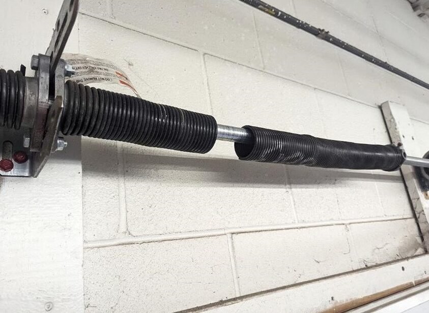 a professional technician performing garage door spring repair in Delaware, Ohio, showcasing expertise and safety measures.